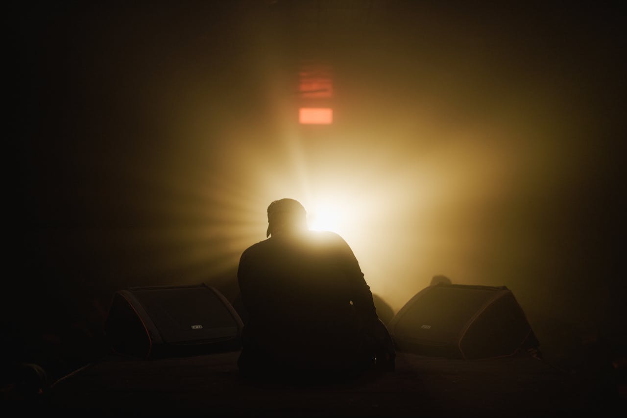 Silhouette of a performer on stage with dramatic backlighting, conveying a sense of mystery and intrigue.